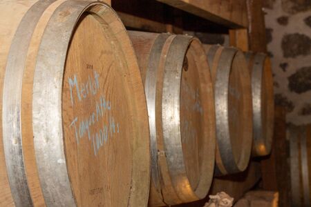 Wine barrels stacked in the old cellar of the winery.の写真素材