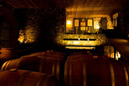 Wine barrels stacked in the old cellar of the winery.の写真素材