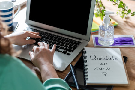 Woman working at home, during the forties due to the coronavirus. He has a notebook with the words...