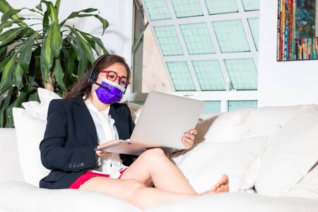Business woman on conference call from home for coronavirus quarantine. face mask.の写真素材