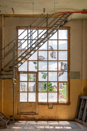 Old broken windows. with metal stairs inside a yellow building. Abandoned spaceの写真素材