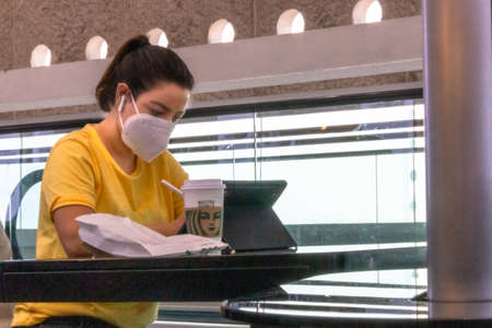 Real woman working on tablet with face mask. New normalのeditorial素材