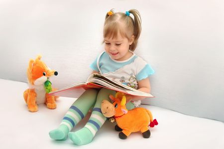 The little girl laughs looking at pictures.の写真素材
