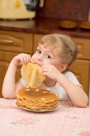 The little girl is naughty behind a table on kitchenの写真素材