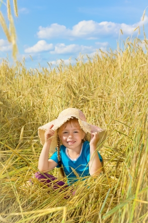 Funny girl sits among the tall rye.の写真素材