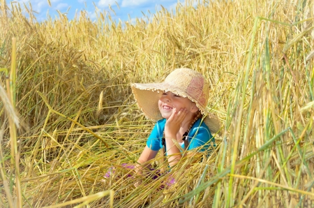 Funny girl sits among the tall rye.の写真素材