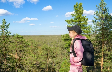 A little girl stands on top and looks into the distance の写真素材