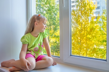 Cheerful girl sitting by the windowの写真素材