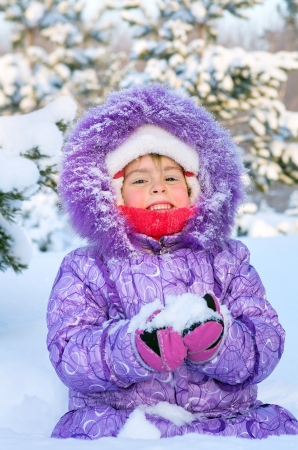 Cheerful little girl playing in a snowy forestの写真素材