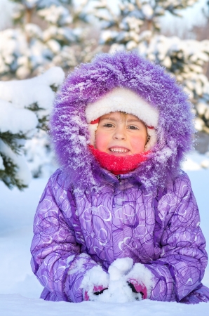 Cheerful little girl playing in a snowy forestの写真素材