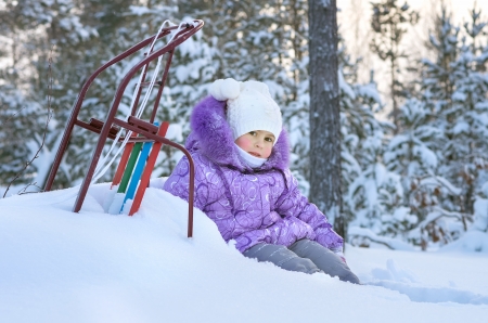 The little girl on a walk in the winter woodsの写真素材