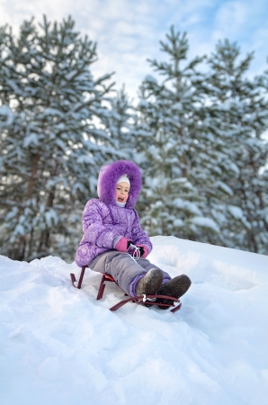Little girl sledding in the winter dayの写真素材