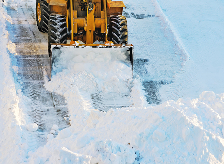Snow drifts. Tractor clears the way after heavy snowfall.の写真素材