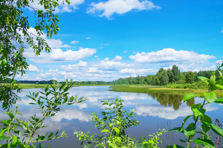 Colorful summer landscape with lake and sky with cloudsの写真素材