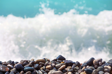 Pebble on the seashore. Background with coastal pebble and rough wavesの写真素材