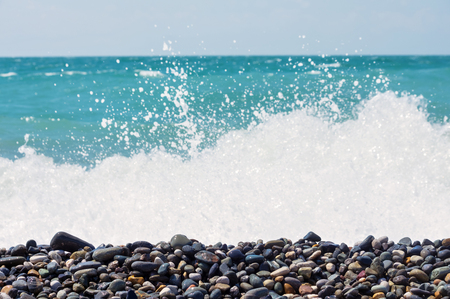 Pebble on the seashore. Background with coastal pebble and rough wavesの写真素材