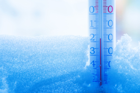 Winter background. Thermometer in the winter on  snow-covered window.の写真素材