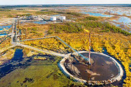Autumn industrial landscape. Western Siberia. Oil torch. Associated gas burning during oil production.の写真素材