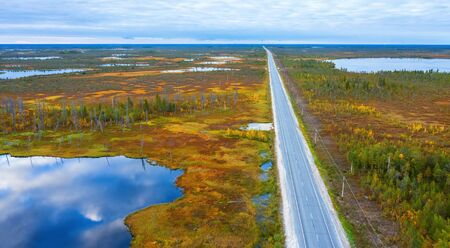 Autumn landscape. West Siberian Plain. Aerial view. Road through endless forests and swamps in Western Siberia.の写真素材