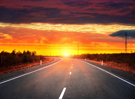 Evening landscape. Car road at sunset with dramatic skyの写真素材
