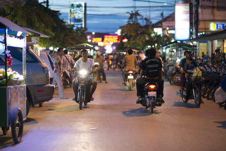 Man riding a motorcycle in Siem Reap traffic. Siem Reap is one of Cambodia's main tourist citiesのeditorial素材