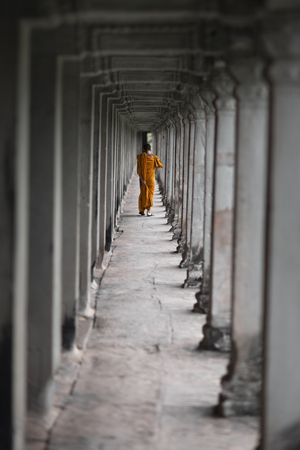 Buddhist monk walking along a gallery of Angkor Wat temple, Siem Reap, Cambodiaの写真素材