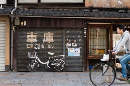 Kyoto, Japan - November 8 2018: A man on his bicycle in front of an old book store in Teramachi Street, Kyoto (Japan)のeditorial素材