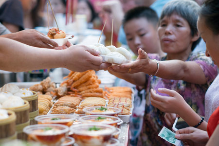 Wangfujing street, Beijing, China - 08 01 2016: Woman buying street food in Wangfujing street, shopping street in Beijing, Chinaのeditorial素材