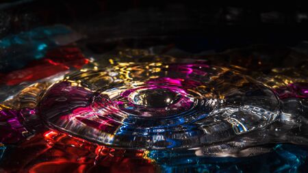 water drops splash forming ripples and waves and abstract water columns in a colorful backgroundの写真素材