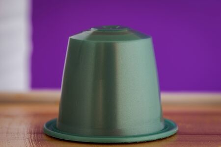 closeup lateral view of an aromatic, tasty espresso gray coffee capsule with purple backgroundのeditorial素材
