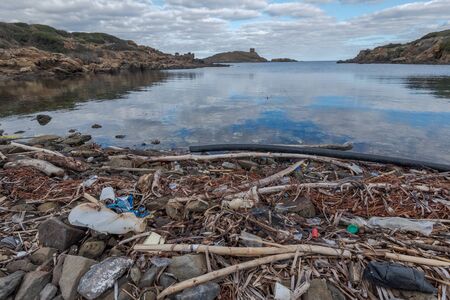plastic pollution mixed with dried seaweed on paradisaical beaches in Menorca, Spainの写真素材