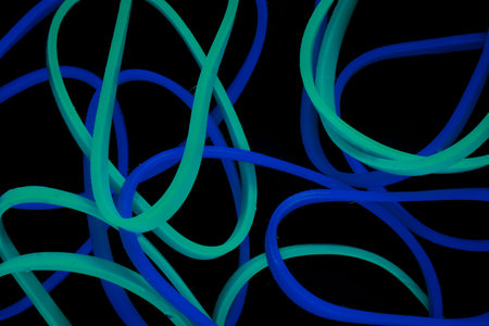 pile of colorful small rubber bands isolated on a black back ground randomly placed