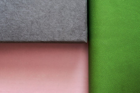 pink, green and dark gray background showing different textures made with cartons and leather