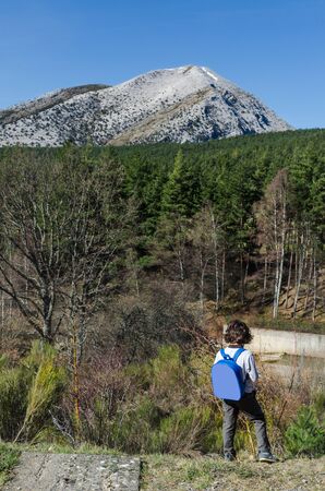 little kids enjoying the landscapes views in the mountains during the winter ending and the spring beginning in a warm sunny dayの写真素材