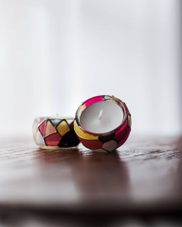 white scented candles in colorful candle holder for relaxing in spa and wellness center with white backgroundの写真素材