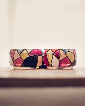 white scented candles in colorful candle holder for relaxing in spa and wellness center with white backgroundの写真素材