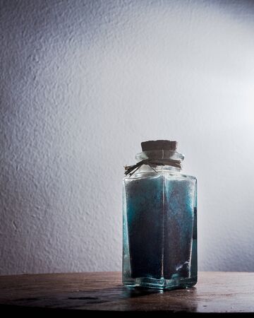 fancy bottle with blue bath salts for relaxing spa treatments with white background illuminated with natural lightの写真素材