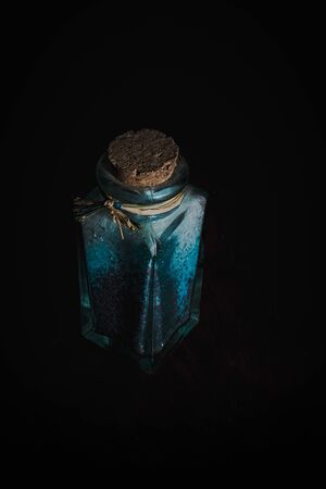 fancy bottle with blue bath salts for relaxing spa treatments with dark wooden backgroundの写真素材