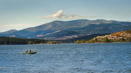 two young athletic men on their kayak canoeing and enjoying the tranquility of Aguilar dam. Palencia, Spain.の写真素材