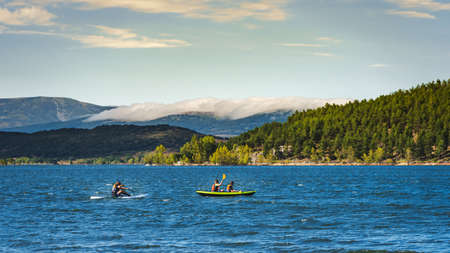 group of young athletic explorers in their kayaks canoeing and enjoying the tranquility of Aguilar dam. Palencia, Spain.の写真素材