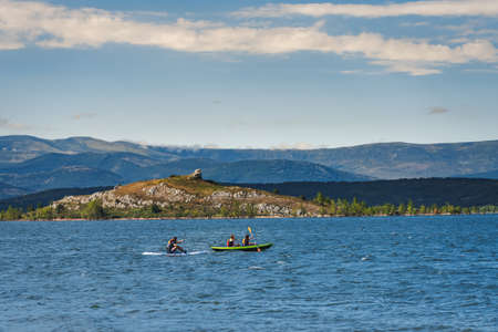 group of young athletic explorers in their kayaks canoeing and enjoying the tranquility of Aguilar dam. Palencia, Spain.の写真素材