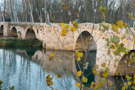 ashlar stone medieval bridge, puente mayor, crossing rio carrion, in autumn. Palencia, Spain.の写真素材