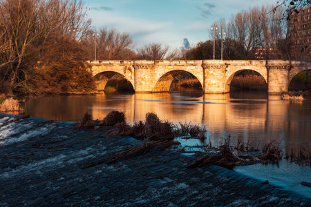 ashlar stone medieval bridge, puente mayor, crossing rio carrion, in autumn. Palencia, Spain.の写真素材