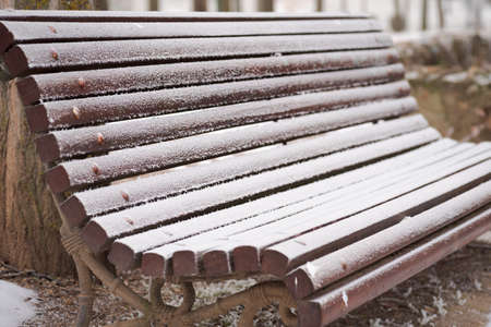 isolated frozen bench with rime and snow after a winter stormの写真素材