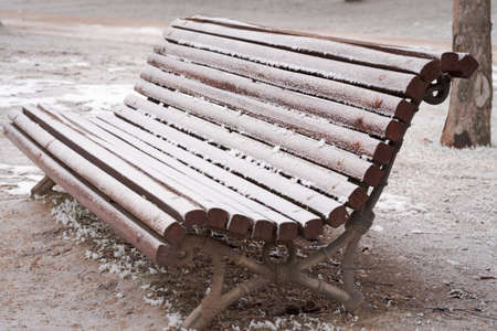 isolated frozen bench with rime and snow after a winter stormの写真素材