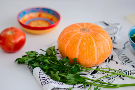 vegetarian food and healthy eating concept - close up of fresh ripe tomatoe, pumpkin and parsley on white tableの写真素材
