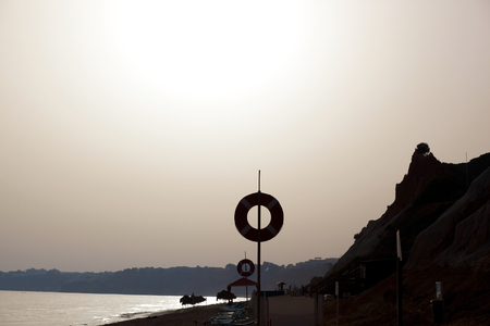 beach at sunset with sun lights in background at algarve, portugalの写真素材
