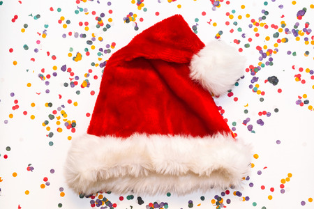 Christmas, winter and holidays season concept. New year style. Santa Claus helper hat  on white background with multicolored confetti. Christmas celebrationの写真素材