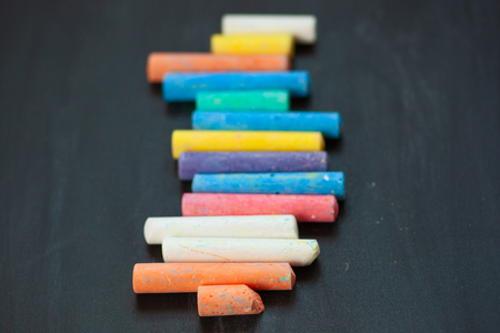 closeup of blackboard with pieces of coloured crayons. Free space for your text. Selective focusの写真素材