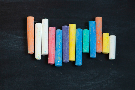 closeup of blackboard with pieces of coloured crayons. Free space for your text. Selective focusの写真素材